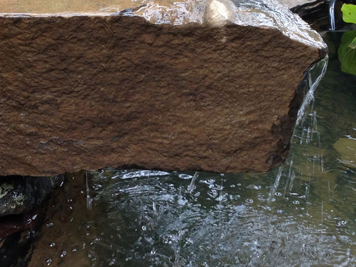 rock sculpture at pond edge